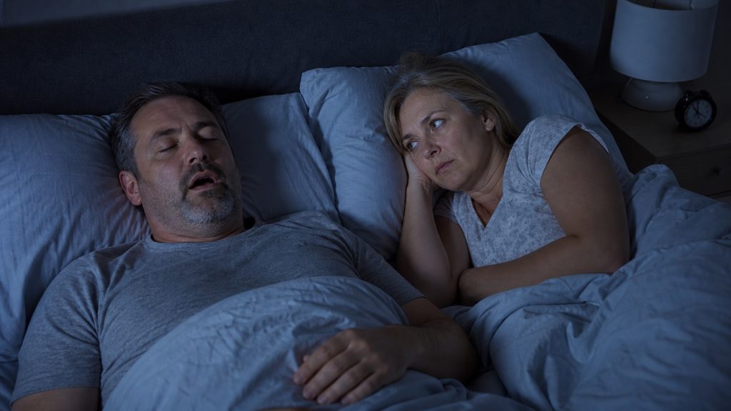 Hombre roncando y mujer despierta durante la noche